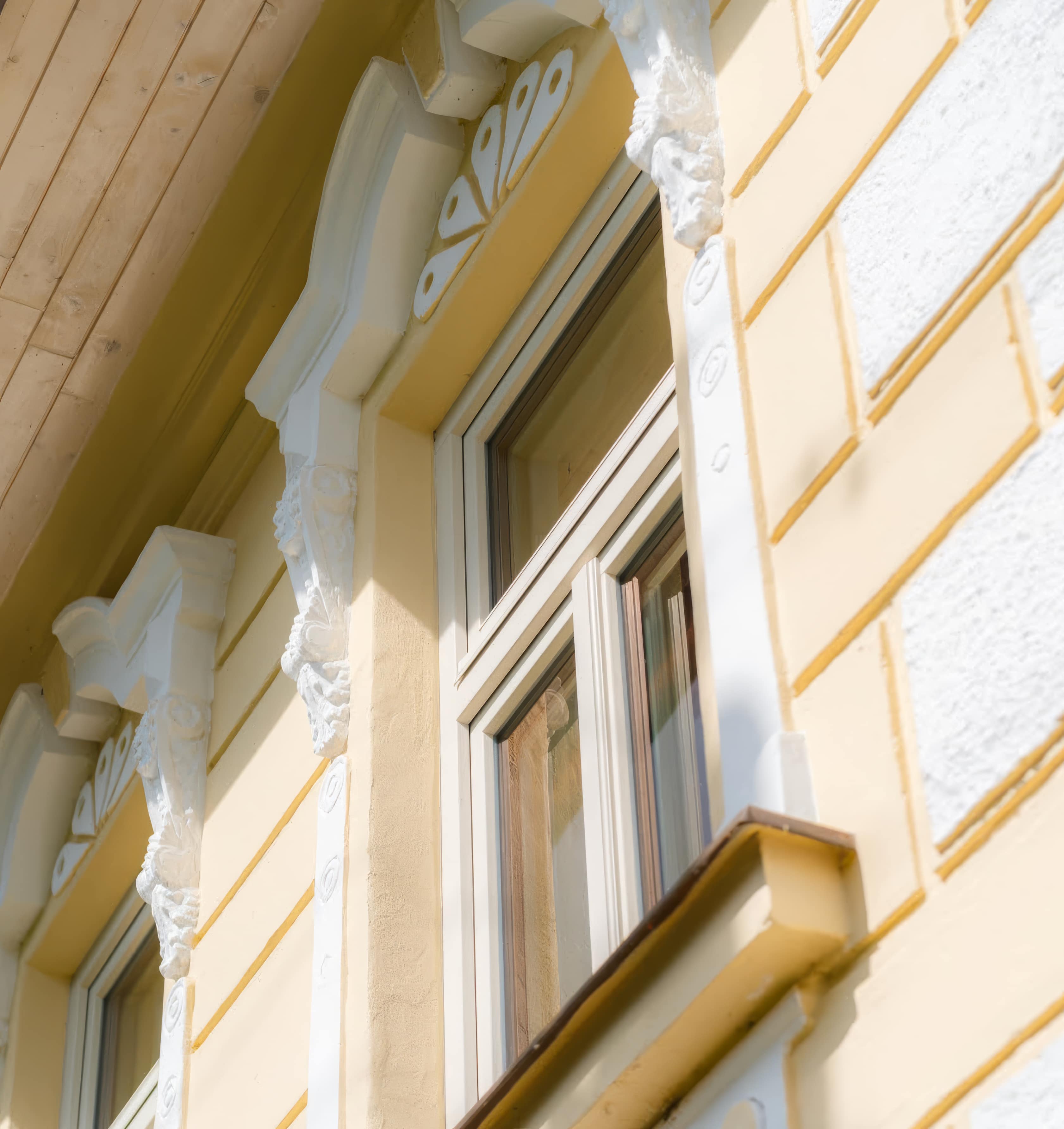 Detail obnovenej historickej fasády a ozdobných prvkov okien.